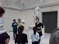clowns in front of marble sculpture